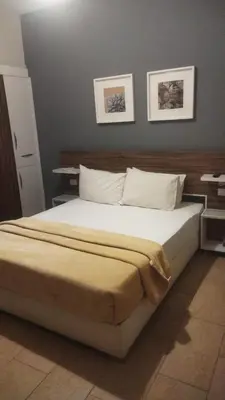a bed in a bedroom with two pictures on the wall at Kite Lodging Hotel in Hurghada
