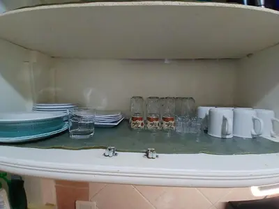 a sink with plates and glasses on a shelf at Arrabia in front of Beirut Hotel in Hurghada