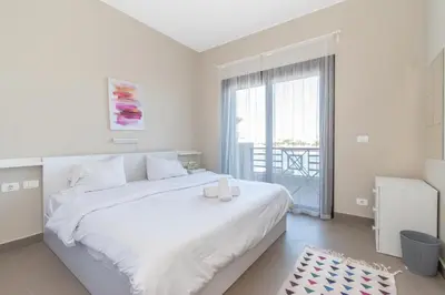 a white bedroom with a large bed and a window at 4 Bdr Villa with private heated pool in Sabina in Hurghada