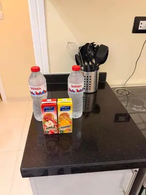 a black counter with two bottles of water and snacks at Oscar apartment 5 in Luxor