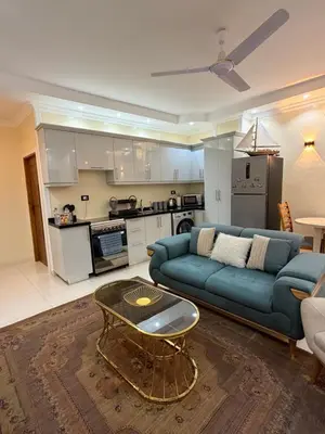 a living room with a blue couch and a table at Oscar apartment 5 in Luxor
