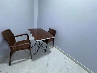 a wooden table and two chairs next to a wall at Peace Homes in Quseir