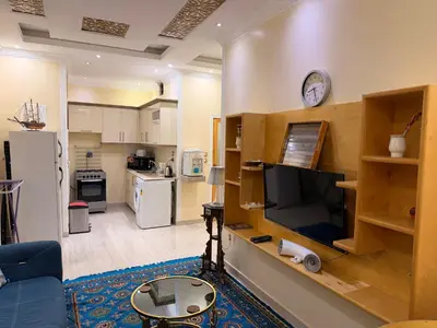 a living room with a tv and a kitchen at Oscar Apartment 2 in Luxor