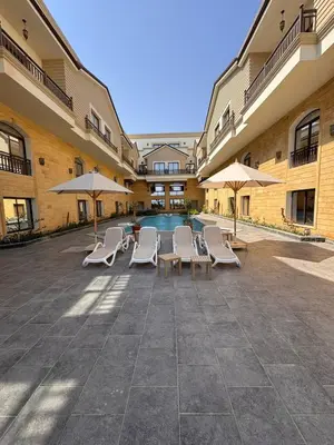 a courtyard with chairs and umbrellas and a pool at 201 Aqua Blue Bay in Hurghada