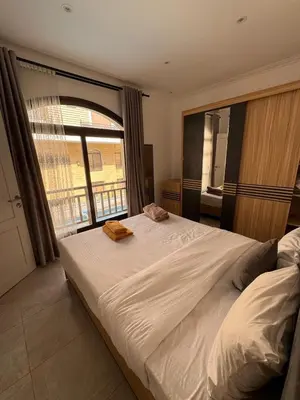 a bedroom with a large white bed with a window at 201 Aqua Blue Bay in Hurghada