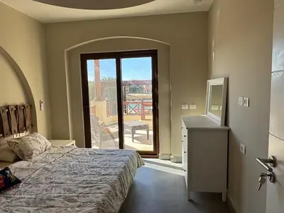 a bedroom with a bed and a view of a balcony at Spacious outdoor area featuring a swimming pool ! in Hurghada