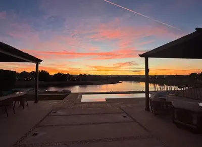 a sunset over a body of water with a patio at Spacious outdoor area featuring a swimming pool ! in Hurghada
