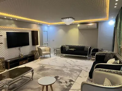 a living room with couches and a flat screen tv at Furnished apartment for rent in Abū Tīj