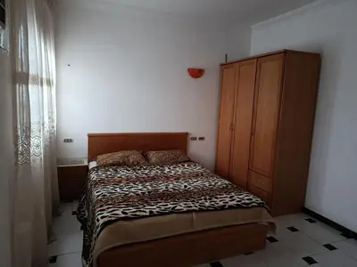 a bedroom with a bed and a wooden cabinet at Rent Mubarak 2 in Hurghada