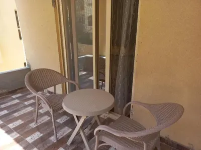 three chairs and a table and a table and chairs at Apartment compound west sayed Al kawthar in Hurghada