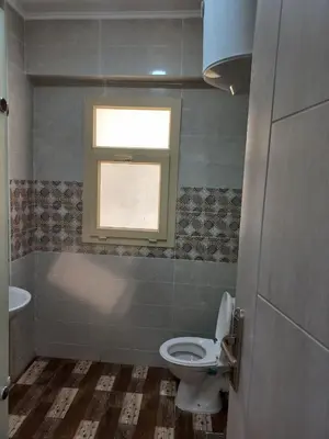 a bathroom with a toilet and a window at Apartment compound west sayed Al kawthar in Hurghada