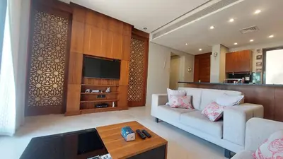 a living room with a couch and a tv at Scenic Cosy Nest - Infinity Pool - Ancient Sands in Hurghada