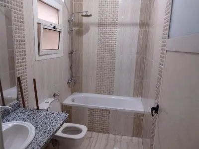 a bathroom with a tub and a toilet and a sink at شقة الغردقة in Hurghada