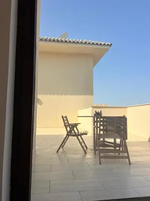 two chairs and a table on a patio at Modern simple apartment with roof in Hurghada