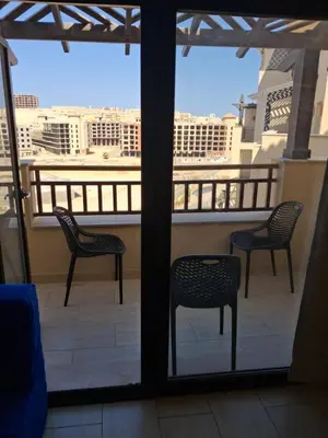 two chairs and a table on a balcony with a view at Modern simple apartment with roof in Hurghada