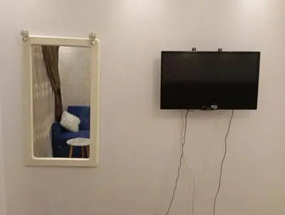 a flat screen tv hanging on a wall next to a mirror at Florenza khamsin Resort Hurghada P109 in Hurghada