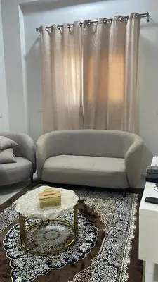 a living room with a couch and a table at mariam Garden in Al Aqālitah