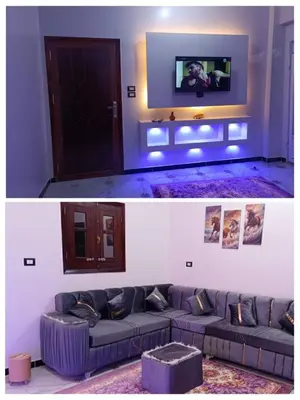 a living room with a couch and a tv at Flower House in Al Aqālitah