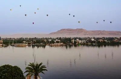a group of kites flying over a body of water at Sun wing guest house in Luxor