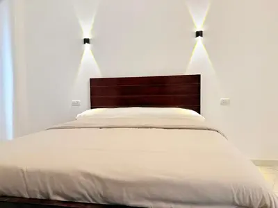 a bedroom with a white bed with two lights above it at Sun wing guest house in Luxor
