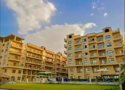 a large apartment building with a lawn in front of it at Cozy Seaside 1BR Apartment B4 in Turtles Beach - Hurghada in Hurghada