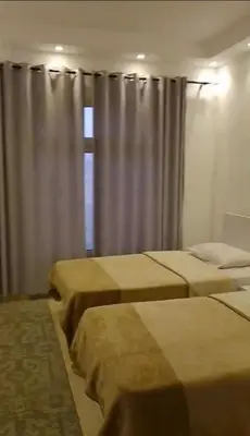 a bedroom with two beds and a window with curtains at Florenza Khamsin Compound Deluxe Apartment C103 in Hurghada