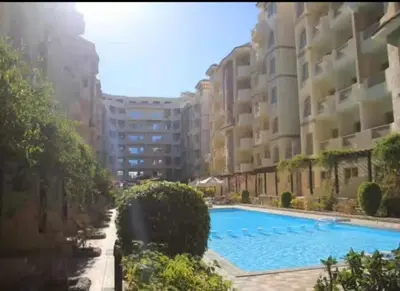a swimming pool in front of some apartment buildings at Florenza Khamsin Compound Deluxe Apartment C103 in Hurghada