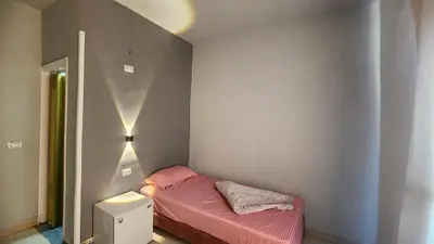 a small bedroom with a small bed with pink sheets at Shapon Hotel - Hurghada in Hurghada