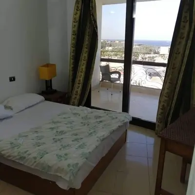 a bedroom with a bed and a view of a balcony at Gomla Flats in Hurghada