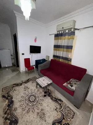 a living room with a red couch and a red chair at cleopatra resort in Hurghada