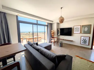 a living room with a couch and a flat screen tv at Stunning Penthouse Seaview Apt in Mesca, Somabay in Hurghada
