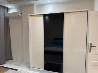 a bedroom with a mirrored closet with a bed in it at 1st Time Rental, 2 BDR Apartment, Pool View, Intercontinental District in Hurghada