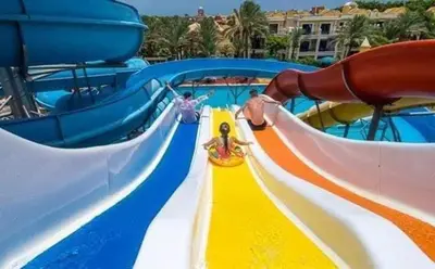 a water slide at a water park with people on it at Mirage Bay Resort & Aqua Park in Hurghada