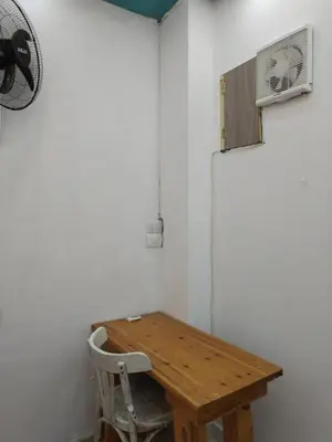 a room with a wooden table and a fan at room 4 a room in Hostel of 4 rooms in Hurghada