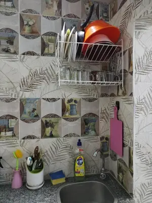 a kitchen with a sink and a tiled wall at room 4 a room in Hostel of 4 rooms in Hurghada