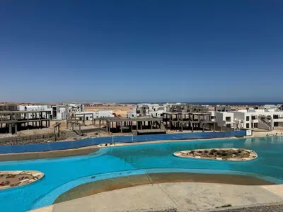 a view of a large swimming pool with buildings in the background at 3 bedrooms penthouse with sea view in Hurghada