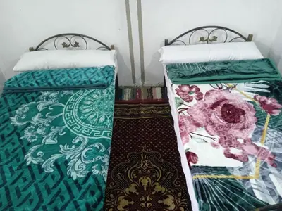 two beds sitting next to each other in a room at Sun Rise House Luxor in Al Aqālitah