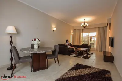 a woman sitting on a couch in a living room at Rivoli Suites in Hurghada