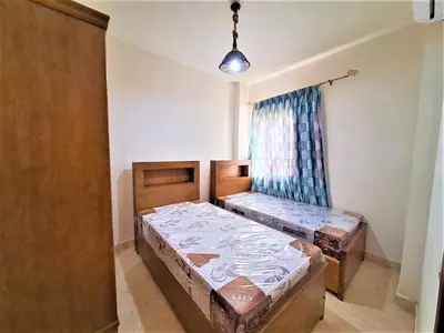 a room with two beds in it with a window at 2BR Makadi heights -cozy Flat in Hurghada
