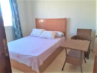 a small bedroom with a bed and a chair at 2BR Makadi heights -cozy Flat in Hurghada