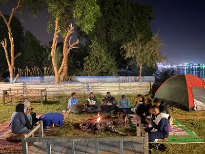 a group of people sitting around a fire at night at Bafana Bafana Nile View Guest House in Aswan