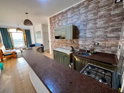 a kitchen with a counter top and a living room at Beautiful desert, mountains, Hurghada skyline view in Hurghada