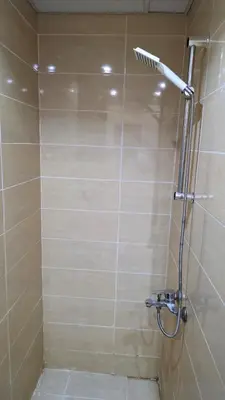 a bathroom with a shower with a tiled wall at florenza-50 in Hurghada