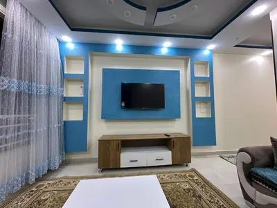 a living room with a tv on a wall at كورنيش القيادات in Hurghada