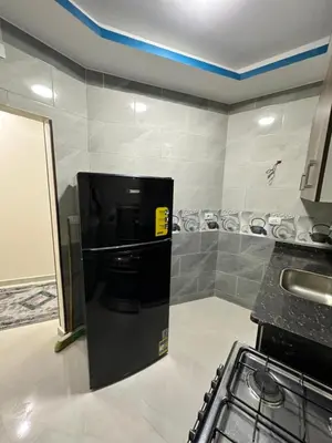 a kitchen with a black refrigerator in a room at كورنيش القيادات in Hurghada