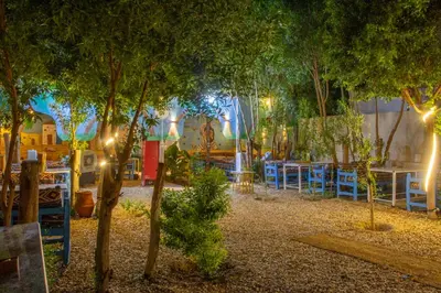 a restaurant with tables and trees at night at Pharaohs Rest Luxor in Luxor