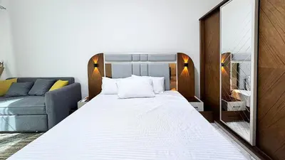 a bedroom with a bed with a mirror and a couch at LA MERA Suite in Hurghada
