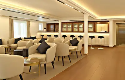 a waiting room with white chairs and tables and a bar at Five-Star Deluxe River Kruz from Aswan to Luxor 3 Nights in Aswān