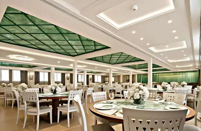 a dining room with tables and chairs and a green ceiling at Five-Star Deluxe River Kruz from Aswan to Luxor 3 Nights in Aswān