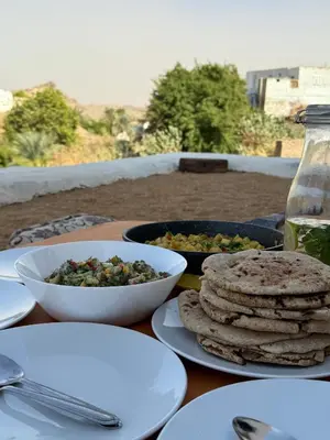 a table with plates of food and bowls of food at Per Ankh - Heissa island - Aswan in Aswan